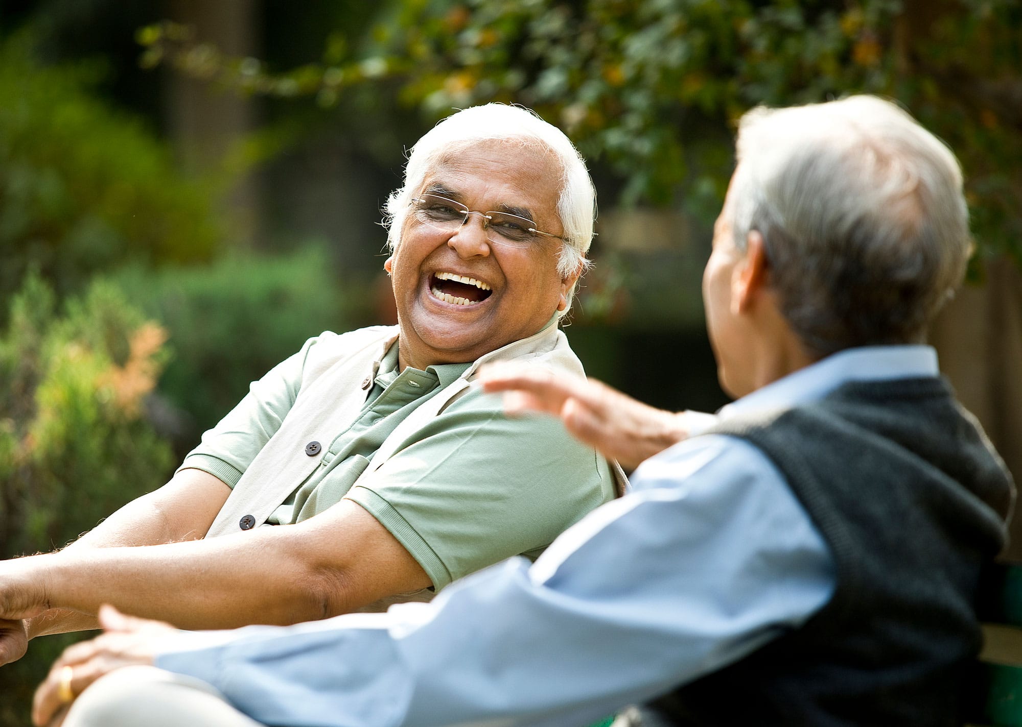 Senior men laughing on park bench