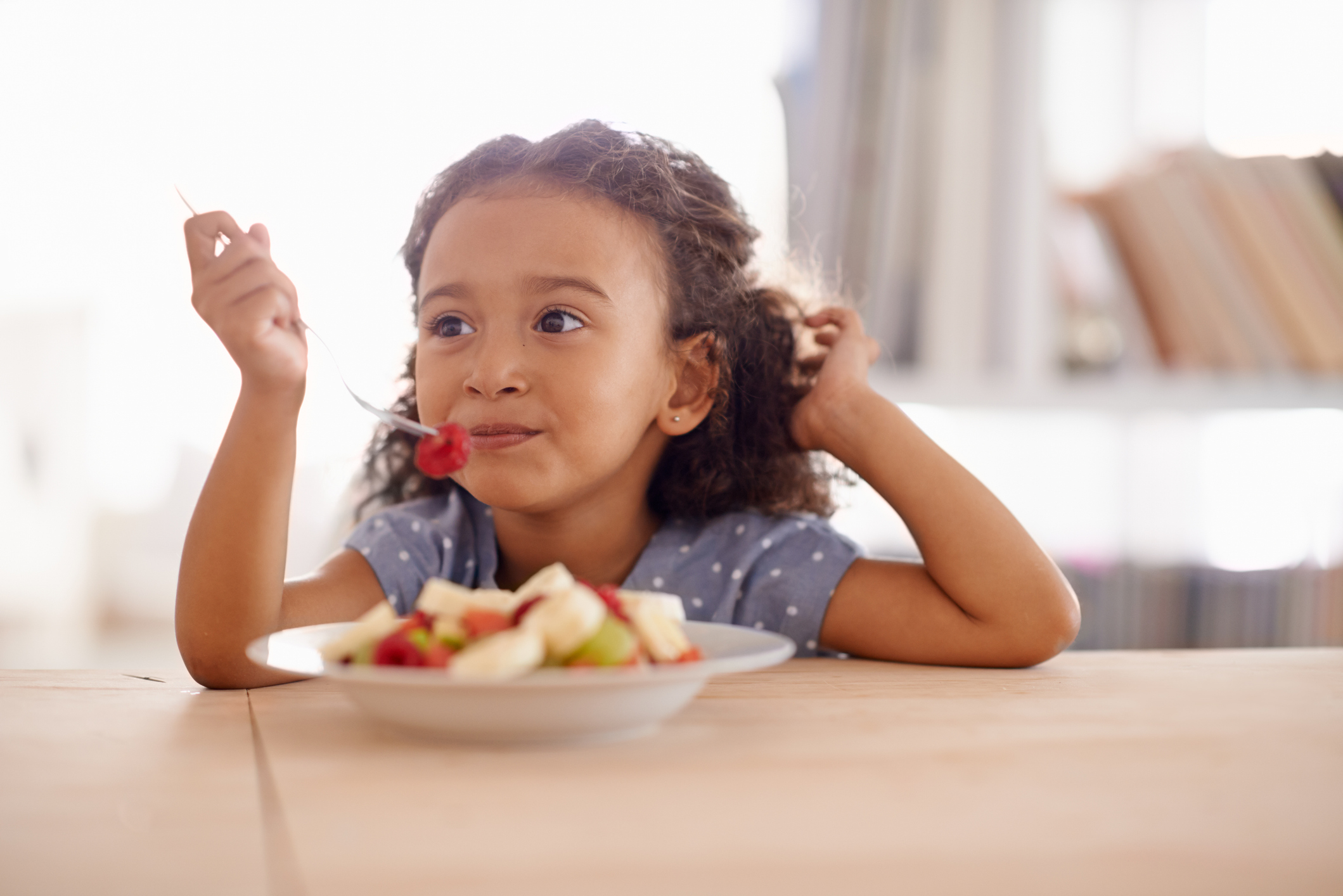 Girl eating fruit salad